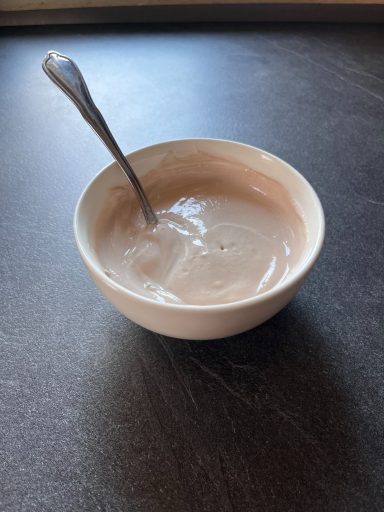 Schüssel mit heller, cremiger Masse und einem Löffel darin.